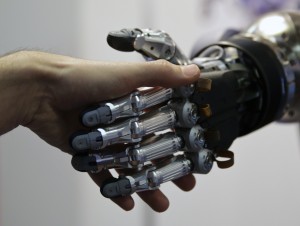 A man shakes hands with a humanoid robot during the International Conference on Humanoid Robots in Madrid November 19, 2014.  REUTERS/Andrea Comas (SPAIN - Tags: SCIENCE TECHNOLOGY) - RTR4ER01